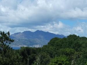a mountain in the distance with trees and water at CASA Beirada Monte y Playa in Carnota