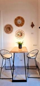 a table with two chairs and a plant on a wall at SUITE LUCIA in Capri