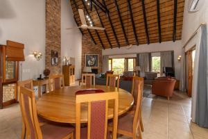 a dining room and living room with a wooden table and chairs at Kruger Park Lodge Unit No 308 with private pool - NYALA LODGE in Hazyview