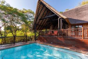 a house with a swimming pool and a deck at Kruger Park Lodge Unit No. 308 in Hazyview