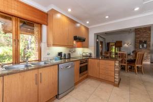 a kitchen with wooden cabinets and a dining room at Kruger Park Lodge Unit No 308 with private pool - NYALA LODGE in Hazyview