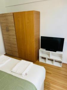 a bedroom with a tv and a bed and a cabinet at Ensuite With Kitchen Ext Large Room With Balcony in Zone 2 in London