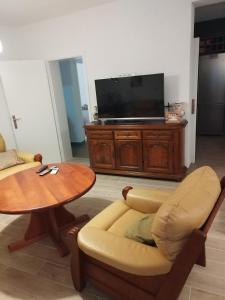 a living room with a table and a tv at Guest House Planinic in Čitluk