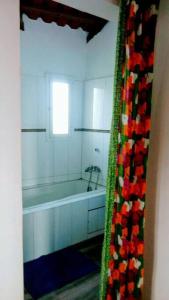 Ndéyane的住宿－La case ronde avec Piscine -Ndayane，带浴缸的浴室和窗户。