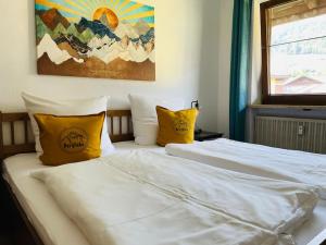 a bed with white sheets and yellow pillows at Berge, Wandern, Erholung pur! Fewo Tinka-Haus Katja in Bad Hindelang