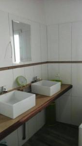 ein Badezimmer mit einem weißen Waschbecken und einem Spiegel in der Unterkunft La case ronde avec Piscine -Ndayane in Ndéyane