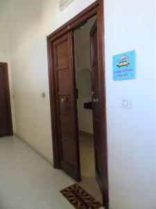 een houten deur in een kamer met een bord erop bij A casa di Pako in Salerno