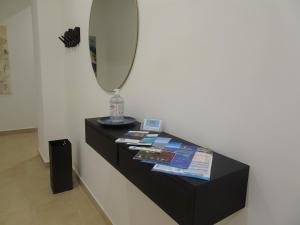 een zwarte dressoir met een spiegel en tijdschriften erop bij A casa di Pako in Salerno +71 foto's