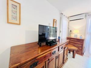 リド・ディ・モンデッロにあるVillino Addauraの木製ドレッサーの上に薄型テレビが備わります。