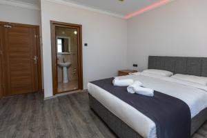 1 dormitorio con 1 cama grande y toallas. en Black Pearly Hotel en Trebisonda