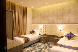 um quarto de hotel com duas camas num quarto em Oriens Hotel em Taif