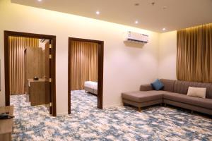 un soggiorno con un divano e un letto di Oriens Hotel a Taif