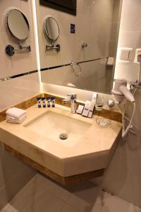 a bathroom with a sink and a mirror at Oriens Hotel in Taif