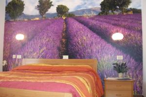 ein Schlafzimmer mit einem Wandbild eines Lavendelfeldes in der Unterkunft B&B da Guerrino in Farra dʼAlpago