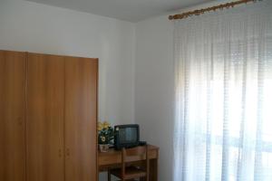 Zimmer mit einem TV auf einem Tisch neben einem Fenster in der Unterkunft B&B da Guerrino in Farra dʼAlpago