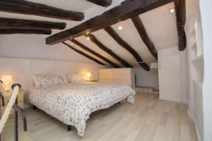 1 dormitorio con 1 cama en una habitación con suelo de madera en Fisherman's house, 1st line of sea en Tarragona