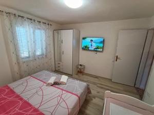 a bedroom with a bed and a tv on a wall at Guesthouse Eljuga Family in Stari Grad