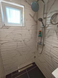y baño con ducha y ventana. en Guesthouse Eljuga Family, en Stari Grad