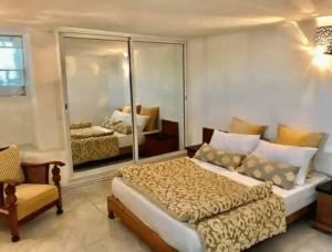 a bedroom with a bed and a chair and a mirror at Sunsets at Fully Equipped Big APT at the Beach in La Marsa
