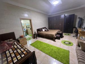 a living room with a bed and a green rug at Oak Chalet شاليه الملول 