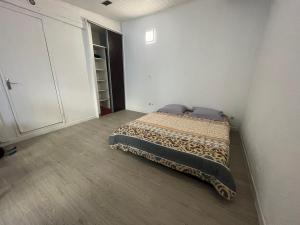 a bedroom with a bed in the corner of a room at EVASION CONVIVIALE in Le Tampon