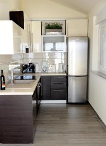 a kitchen with a stainless steel refrigerator and wooden floors at Apartment Lara in Vodice +12 photos