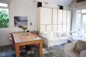 een woonkamer met een tafel en een witte bank bij Cottage Markdal in Breda