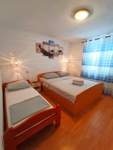 a bedroom with two beds and a window at Guesthouse Eljuga Family in Stari Grad