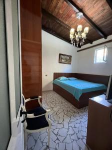 a bedroom with a bed and a chair at BlackStone.Shkodra in Shkodër