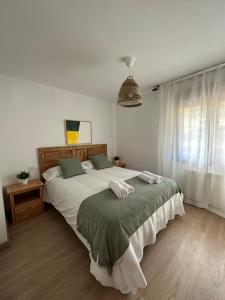 a bedroom with a large bed with two towels on it at AIRE DE PICOS Sur in Brez
