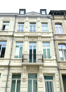 ein hohes Gebäude mit Fenstern und einem Balkon in der Unterkunft European Comission Beautiful Studio in Brüssel