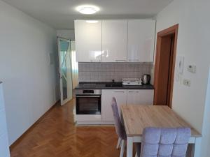 a kitchen with a wooden table and a kitchen with white cabinets at Eko Eko in Rijeka