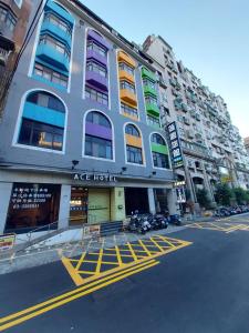 ein Gebäude auf einer Straße mit davor geparkt in der Unterkunft 蓮園旅舘-桃園店 in Taoyuan