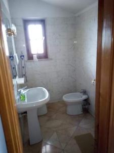 bagno bianco con lavandino e servizi igienici di Villa dolce a Massa