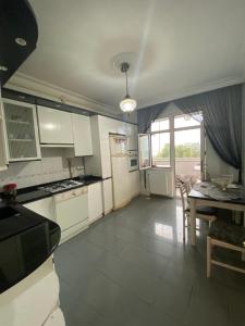 a kitchen with white appliances and a table with chairs at Kültür Suite meydan in Trabzon