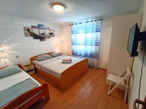 a bedroom with a bed and a television in it at Guesthouse Eljuga Family in Stari Grad
