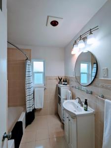 La salle de bains est pourvue d'une baignoire, d'un lavabo et d'un miroir. dans l'établissement Group Friendly Lakefront Retreat 3BR, à Orlando