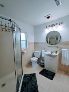 La salle de bains est pourvue d'une douche, de toilettes et d'un lavabo. dans l'établissement Group Friendly Lakefront Retreat 3BR, à Orlando