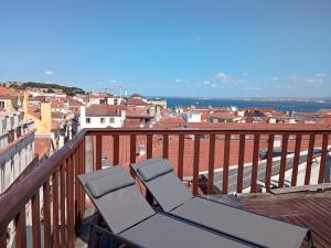 un sillón en un balcón con vistas a la ciudad en My View Over Lisbon, en Lisboa