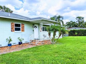une maison blanche avec un palmier dans une cour dans l'établissement Group Friendly Lakefront Retreat 3BR, à Orlando