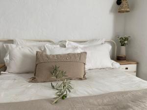 a white bed with white pillows and a pillow on it at Casa Vó Briata in Mértola