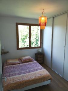 Schlafzimmer mit einem Bett, einem Fenster und einem Kronleuchter in der Unterkunft Belle vue au cœur du Châtillonnais in Aisey-sur-Seine