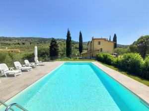 una piscina di fronte a una villa di Casa Giulia a Reggello