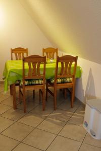 einen Tisch mit vier Stühlen und einem grünen Tischtuch in der Unterkunft Gästehaus am Kirschberg in Ilsenburg