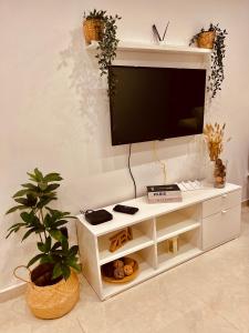 um centro de entretenimento branco com uma televisão de ecrã plano na parede em Casa Relax em Playa Blanca