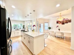 New Modern Spacious 4bdr Home by Golden Gate Park في سان فرانسيسكو: مطبخ مع دواليب بيضاء وغرفة طعام