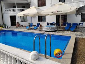 a swimming pool with a volley ball and umbrellas at Vila Jovana A in Rogljevo