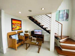 a living room with a couch and a table and stairs at Cebu City Huge Lofts by P&J in Cebu City
