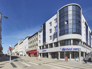 - un grand bâtiment blanc dans une rue de la ville dans l'établissement Kyriad Hotel Brest, à Brest