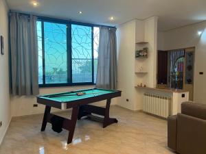 mesa de ping pong en la sala de estar con ventana en Casa Vacanze Al Vesuvio, en Trecase